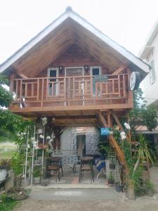 a large wooden house with a table and chairs at JE House in Ambarita +8 photos