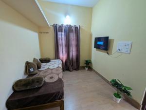 a small room with a couch and a tv in it at Sri Krishna 4BHK AC Villa in Udupi +8 photos