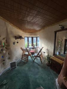 a room with a table and chairs and a mirror at The Cob House in Chauntrā
