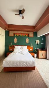 a bedroom with a large bed with a green wall at Zeman Villa in Padang