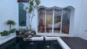 a house with a swimming pool and a bedroom at Zeman Villa in Padang