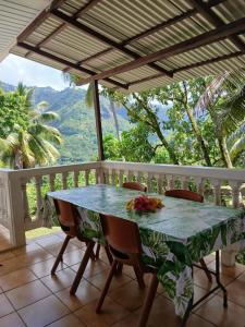 a table and chairs on a balcony with a view at Hiva Oa Villa Lodge in Hiva Oa