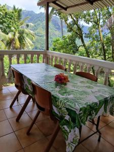 a table and chairs on a balcony with a view of the mountains at Hiva Oa Villa Lodge in Hiva Oa