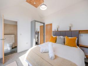 a bedroom with a large white bed with yellow pillows at The Stables - Uk49089 in Crediton +12 photos