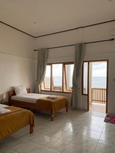 a bedroom with two beds and a view of the ocean at Villa Redemptorist in Weetebula
