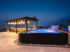 a swimming pool on top of a building at night at Hotel Urban chant in Rishīkesh