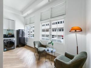 a living room with two chairs and a table at The White House - Serviced Residences by Cove & Belle Living in Singapore