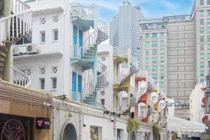 a group of tall buildings with stairs on them at The White House - Serviced Residences by Cove & Belle Living in Singapore