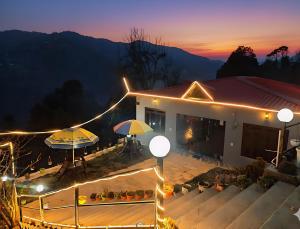 a house with a table and umbrellas at night at A Home Above the Clouds Riturain Mukteshwar in Mukteshwar