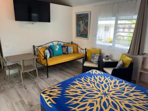 a bedroom with a bed and a couch and a table at Blue Sky Cozy in Paea
