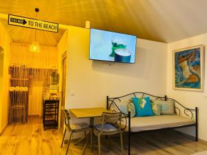 a room with a couch and a table and a tv at Blue Sky Cozy in Paea