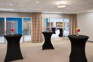 a conference room with black tables and flowers on them at EVEN Hotel Pittsburgh Downtown by IHG in Pittsburgh
