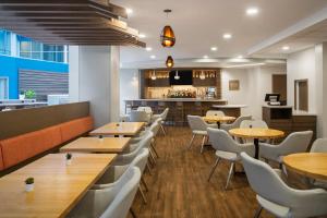 a restaurant with wooden tables and white chairs at EVEN Hotel Pittsburgh Downtown by IHG in Pittsburgh