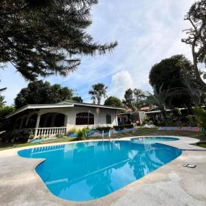 a swimming pool in front of a house at Alaba Vacation House w Pool and Beach Access in Mambajao +19 photos