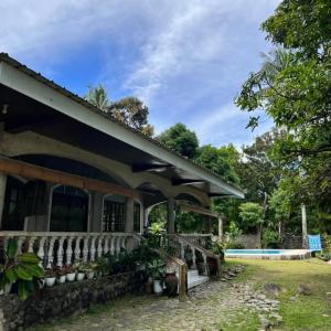 a house with a porch and a fence at Alaba Vacation House w Pool and Beach Access in Mambajao