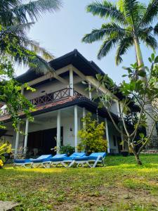 a resort with blue lounge chairs in front of a building at Sri Villa in Dickwella