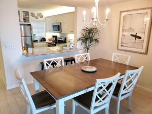 a dining room and kitchen with a wooden table and chairs at Summerhouse 104- Direct Oceanfront condo in St. Augustine