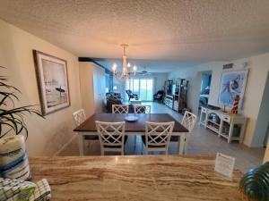 a dining room and living room with a table and chairs at Summerhouse 104- Direct Oceanfront condo in St. Augustine +26 photos