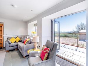 a living room with two couches and a large window at The Stables - Uk49089 in Crediton