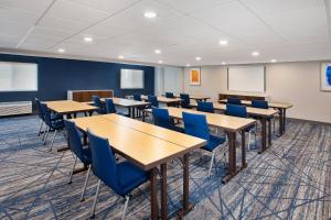 a classroom with wooden tables and blue chairs at Holiday Inn Express Casper I-25 by IHG in Casper +49 photos