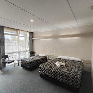 a hotel room with two beds and a table and chairs at Wangaratta Motor Inn in Wangaratta +61 photos