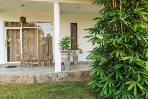 a porch of a house with two chairs and a table at Lost Paradise Sri Lanka in Mirissa