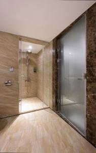 a shower with a glass door in a bathroom at Noble Hotel in Taipei