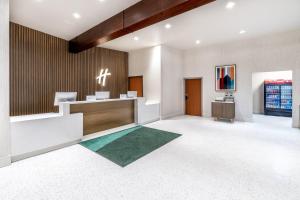 Eine Bürolobby mit Empfangstresen und grünem Teppich in der Unterkunft Holiday Inn Frisco by IHG in Frisco + 51 Fotos