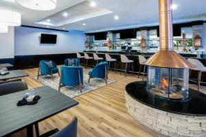 ein Restaurant mit Tischen, Stühlen und einem Kamin in der Unterkunft Holiday Inn Frisco by IHG in Frisco