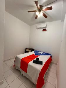 a bedroom with a bed with a ceiling fan at Grandma House in Carolina