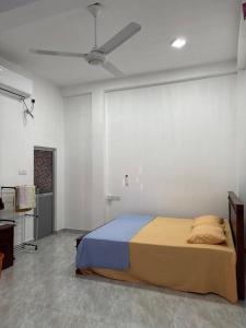 a bedroom with a bed and a ceiling fan at Nikita Homestay in Kosgoda