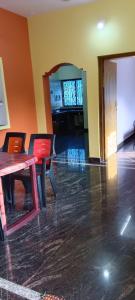 a dining room with a table and chairs in a room at Ronith's Cozy Stay in Gokarna