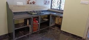 a kitchen with a fire hydrant under a counter at Ronith's Cozy Stay in Gokarna
