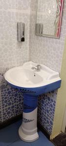 a bathroom with a white sink and a mirror at Ronith's Cozy Stay in Gokarna