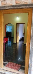 an open door to a living room with a table at Ronith's Cozy Stay in Gokarna