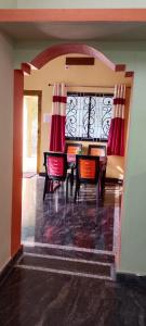 a dining room with a table and chairs at Ronith's Cozy Stay in Gokarna