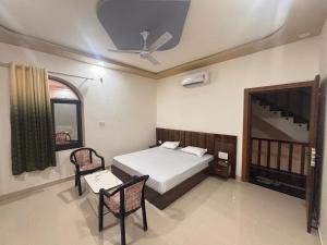 a bedroom with a bed and a table and a ceiling at Hotel KK palace in Chittaurgarh