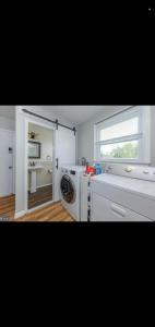 a kitchen with a washing machine and a window at The Carneys Point Cottage in Friendship Station