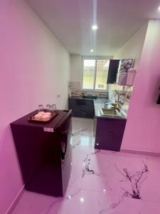 a pink kitchen with a counter and a sink at Cabana suites in Rishīkesh