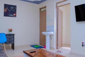 a bathroom with a sink and a tv in a room at Happy Home Ke in Isiolo
