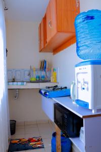 a kitchen with a coffee maker on top of a microwave at Happy Home Ke in Isiolo