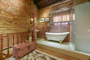 a bathroom with a tub and a brick wall at Ohana House HQ in Malacca +219 photos