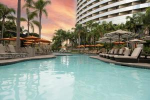 a swimming pool with chairs and umbrellas in a hotel at Marriott Marquis San Diego Marina in San Diego