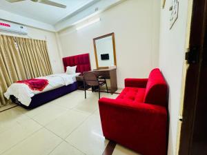 a bedroom with a bed and two red chairs at Hotel Sarbick International in Kukrāil