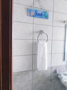 a white towel hanging on a wall in a bathroom at Casa Rosa in Nanyuki