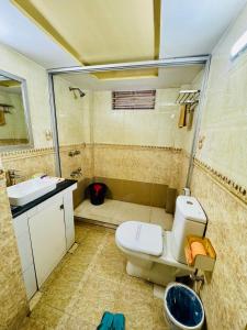 a bathroom with a toilet and a sink at Hotel Sarbick International in Kukrāil