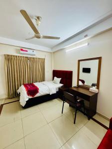 a bedroom with a bed and a desk and a mirror at Hotel Sarbick International in Kukrāil