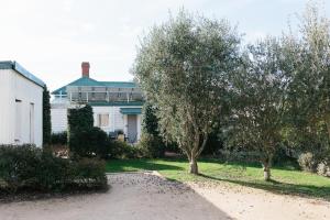 einen Hof mit zwei Bäumen und einem Haus in der Unterkunft Isabella at Kyneton in Kyneton
