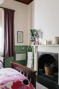 ein Schlafzimmer mit einem Bett und einem Kamin in der Unterkunft Isabella at Kyneton in Kyneton