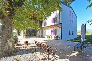 a bench sitting under a tree next to a building at Agriturismo Corte Bonetti in Pescantina